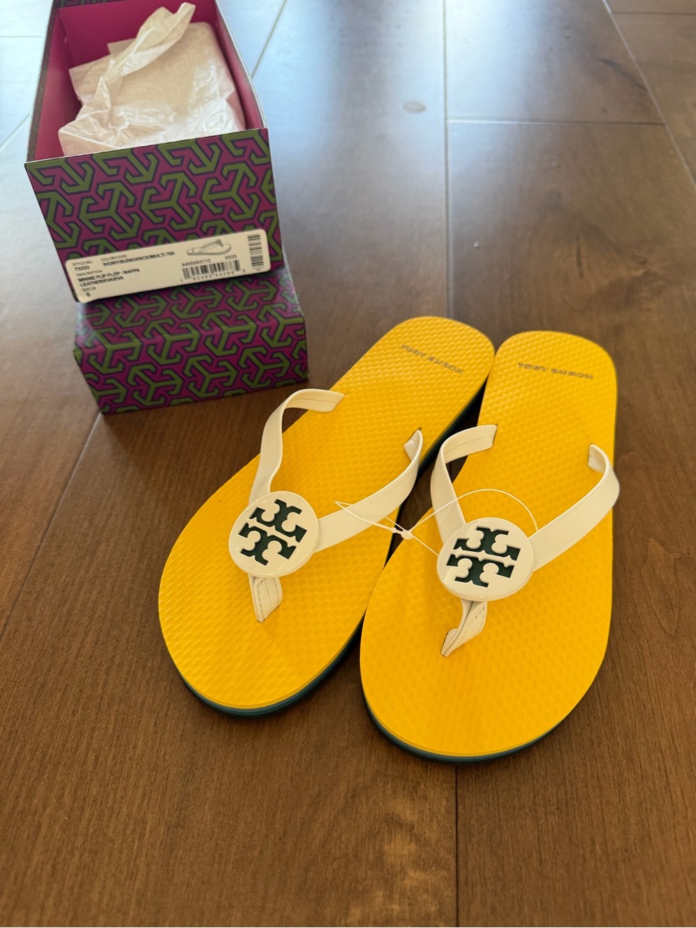 Tory Burch women’s Yellow Flip Flops with White Straps and Logo Medallion